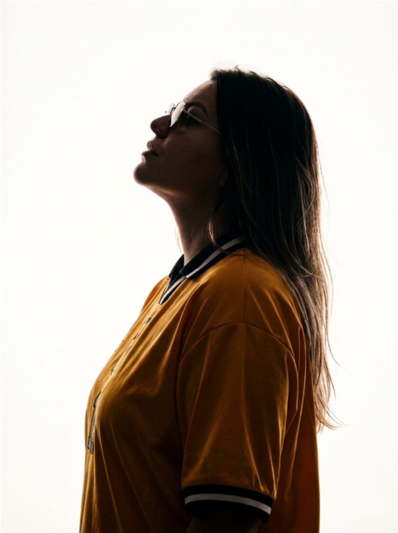 Lorena Mariano de perfil em contraluz, vestindo camisa de time
